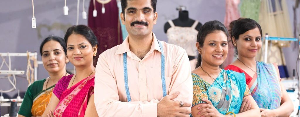 Male and female textile workers standing together in solidarity at factory